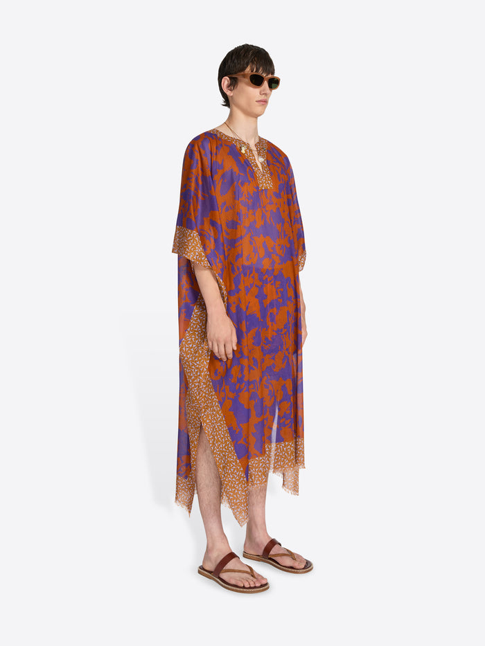 Person wearing a patterned dress on a white background