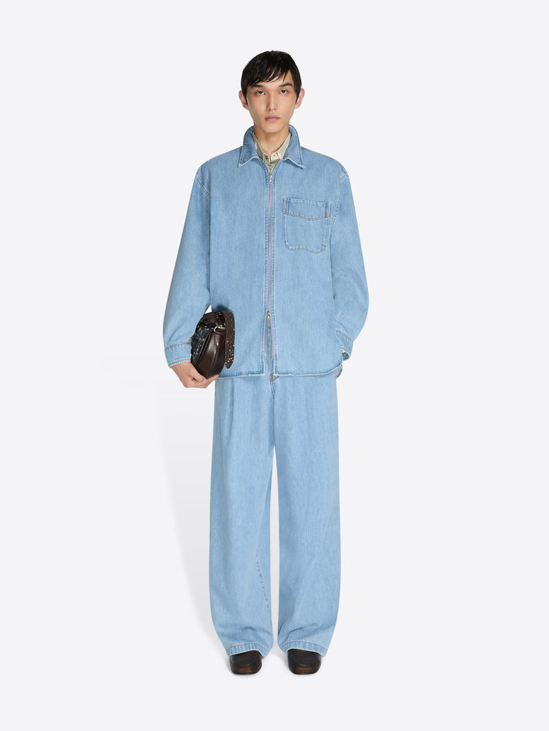 Person wearing a light blue denim jumpsuit on a white background - Dries Van Noten