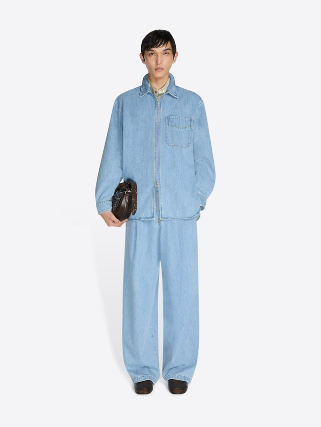 Person wearing a light blue denim jumpsuit on a white background - Dries Van Noten