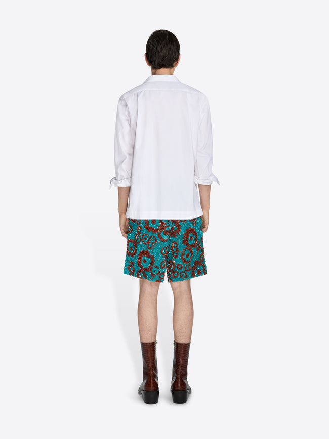 Person wearing a white shirt and floral skirt on a white background