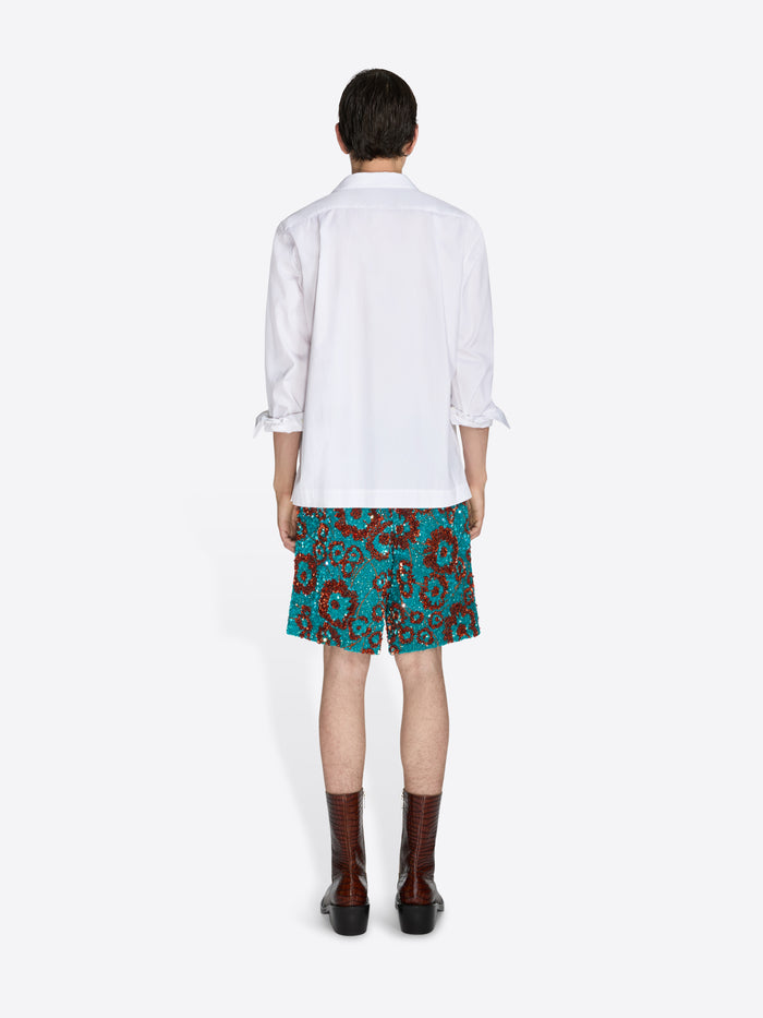 Person wearing a white shirt and floral skirt on a white background