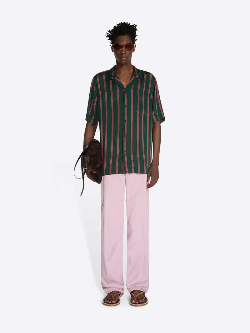 Person wearing a striped shirt and pink pants on a white background