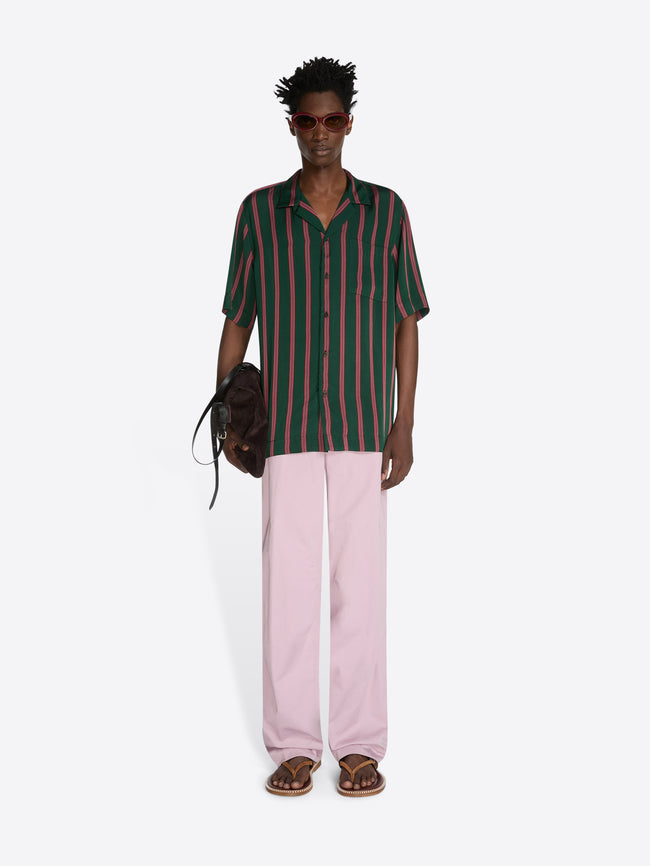 Person wearing a striped shirt and pink pants on a white background