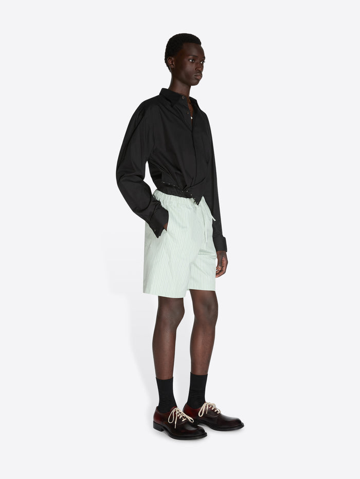 Person wearing a black shirt and white shorts on a white background