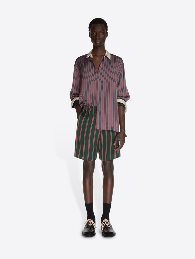 Person wearing a striped shirt and shorts on a white background - Dries Van Noten