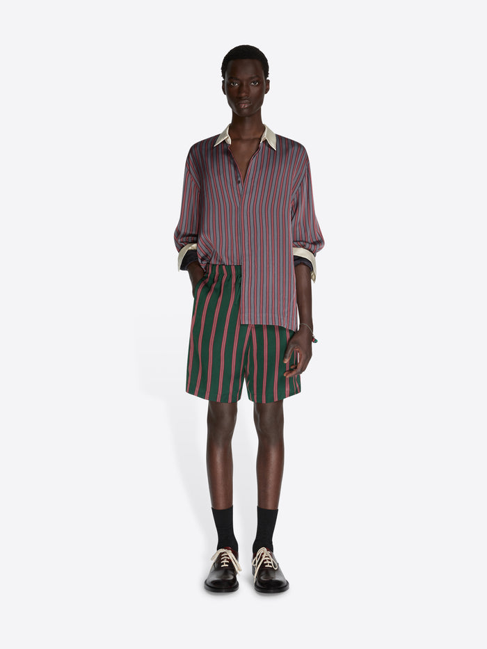 Person wearing a striped shirt and shorts on a white background - Dries Van Noten