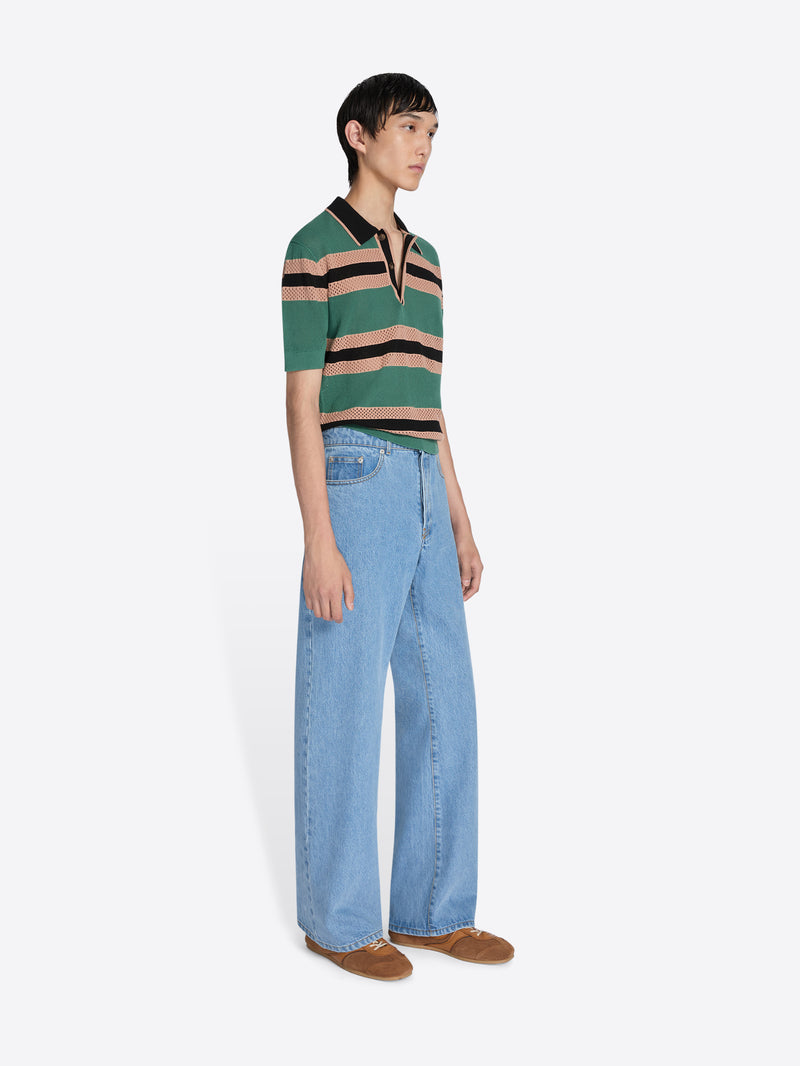 Person wearing a striped shirt and jeans on a white background