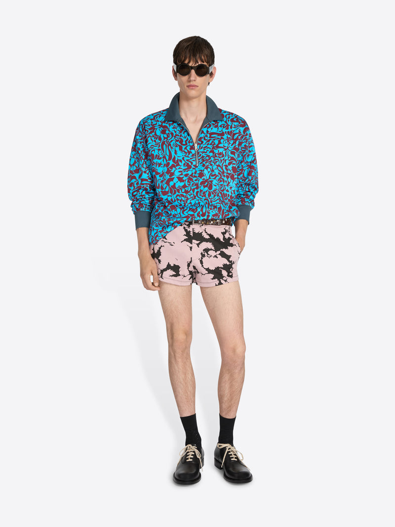 Person wearing a colorful jacket and shorts on a white background