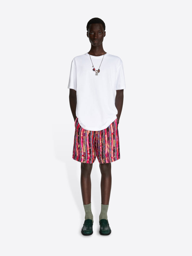 Person wearing a white t-shirt and colorful shorts on a white background