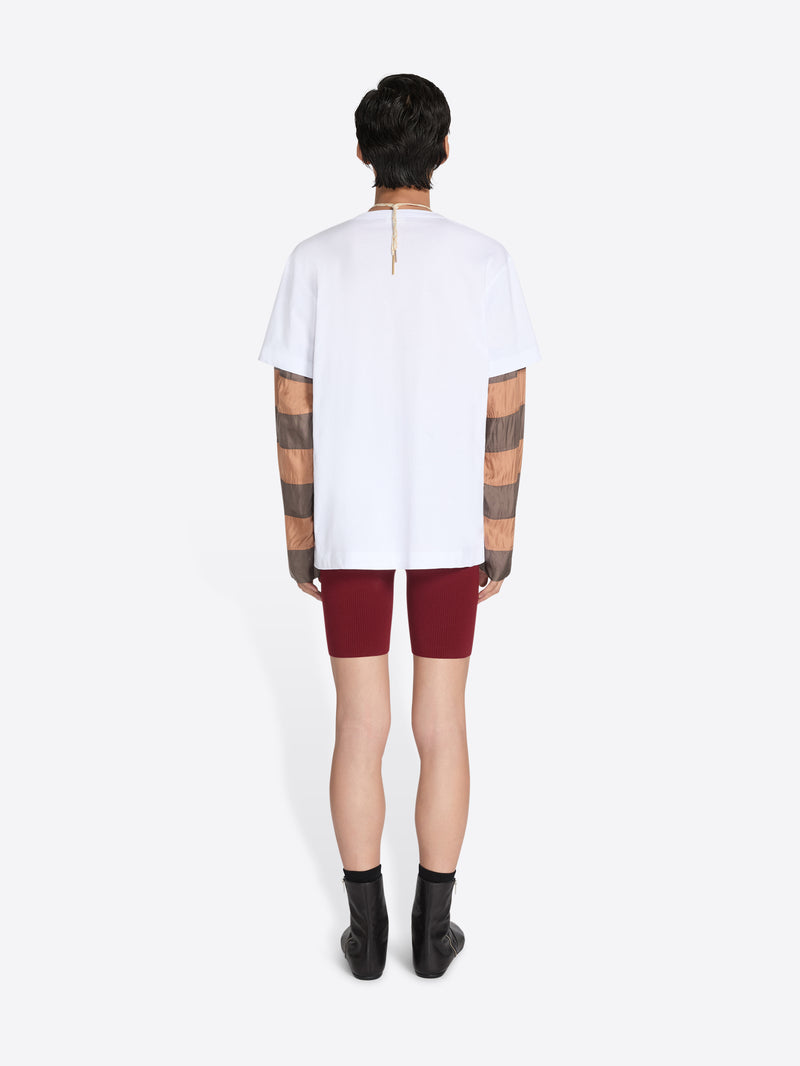 Person wearing a white t-shirt and maroon shorts on a white background