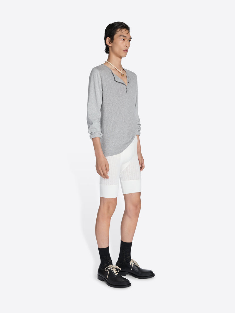 Person wearing a gray sweater and white shorts on a white background - Dries Van Noten