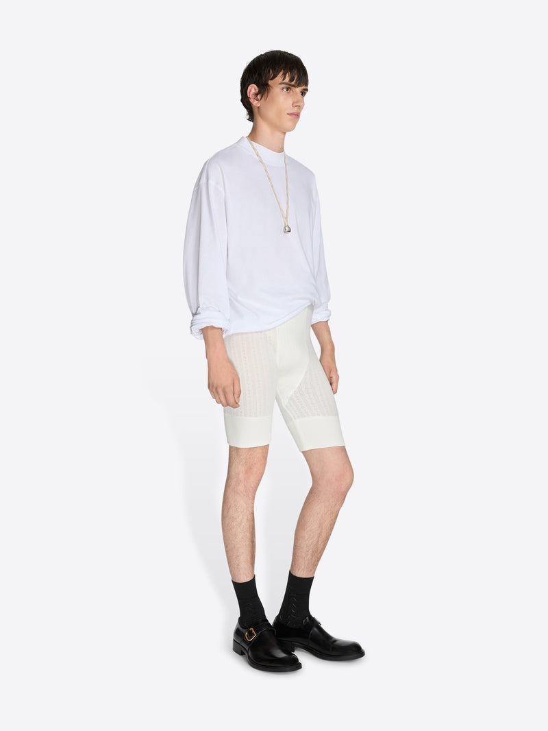 Person wearing a white outfit with black shoes on a white background - Dries Van Noten