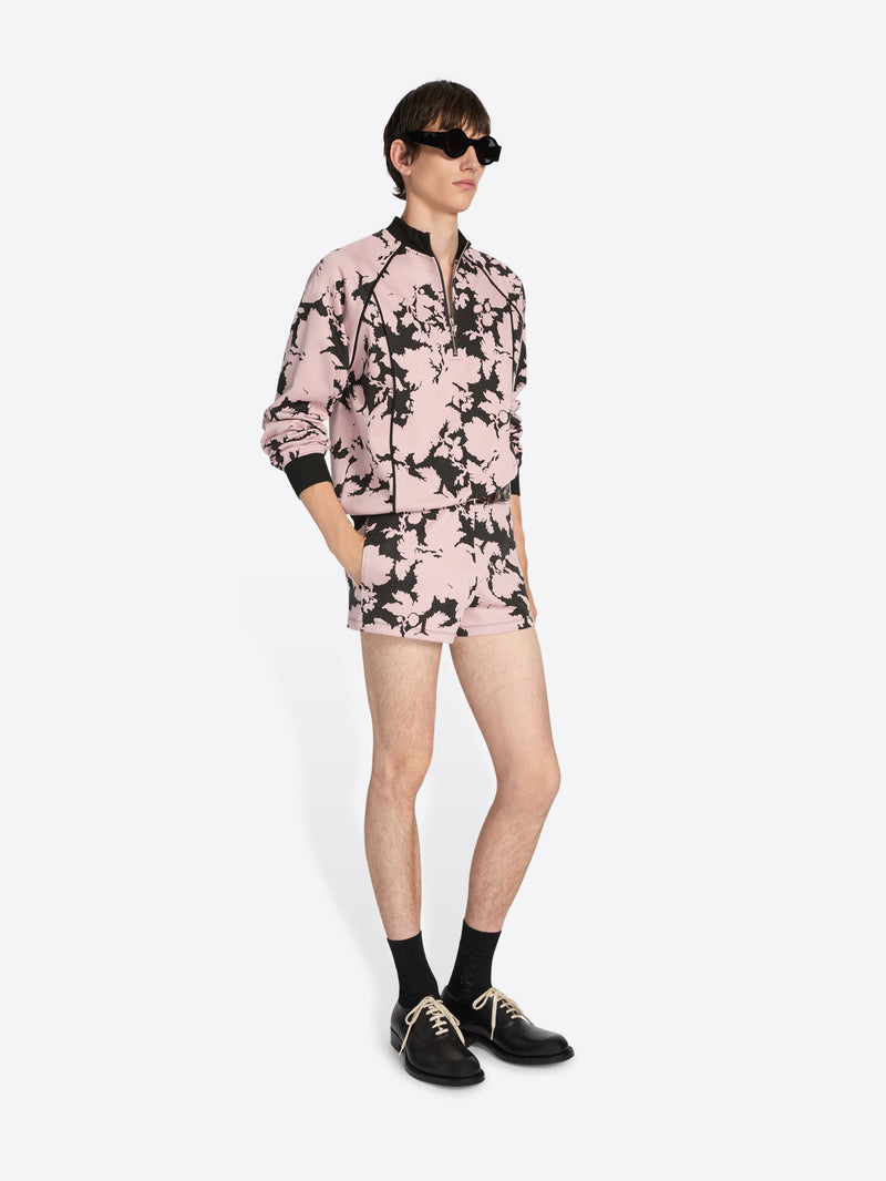 Person wearing a pink floral outfit on a white background
