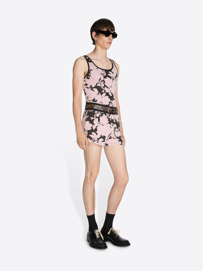 Person wearing a pink floral dress with black accents on a white background