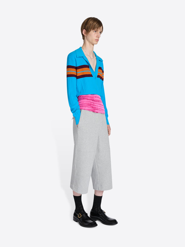 Person wearing a colorful striped sweater and gray pants on a white background - Dries Van Noten