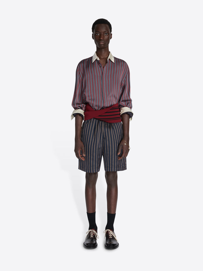 Man wearing a striped shirt and shorts on a white background