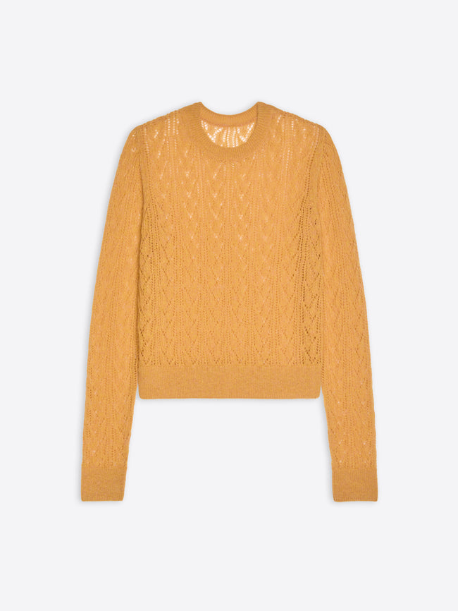 Mustard yellow cable knit sweater on a light gray background