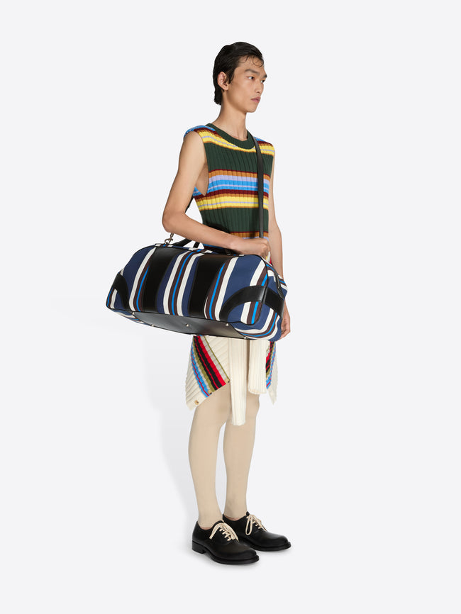 Person holding a striped duffel bag against a white background - Dries Van Noten