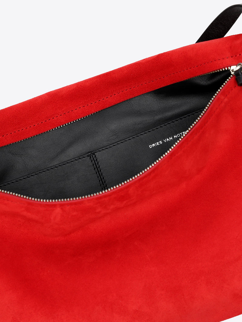 Close-up of a red bag with black interior and visible brand name. - Dries Van Noten