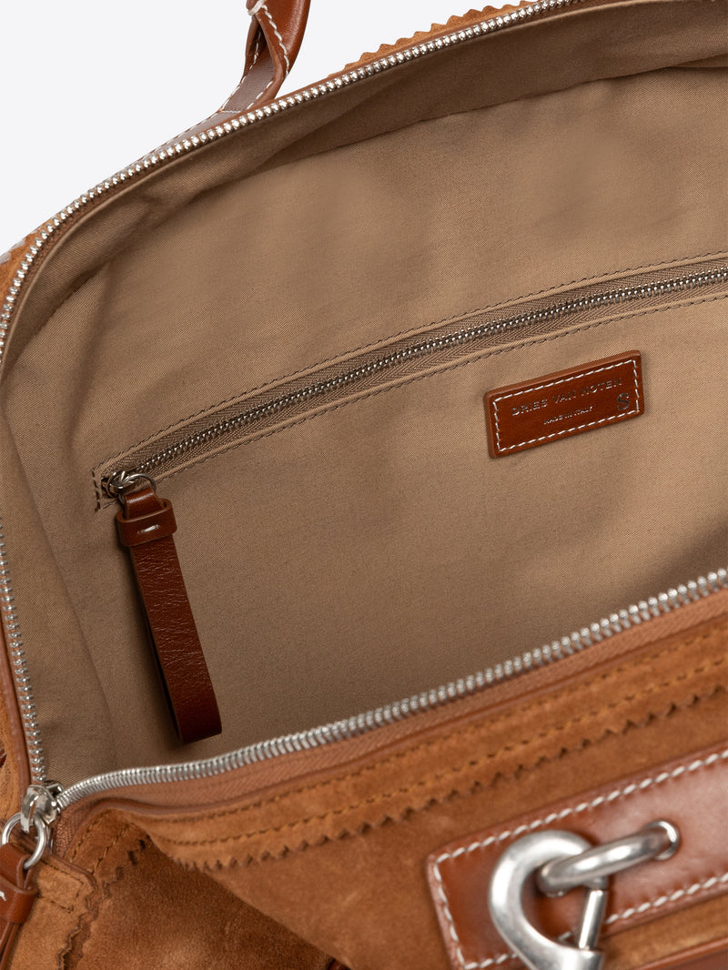 Close-up of a brown leather bag with visible stitching and hardware. - Dries Van Noten