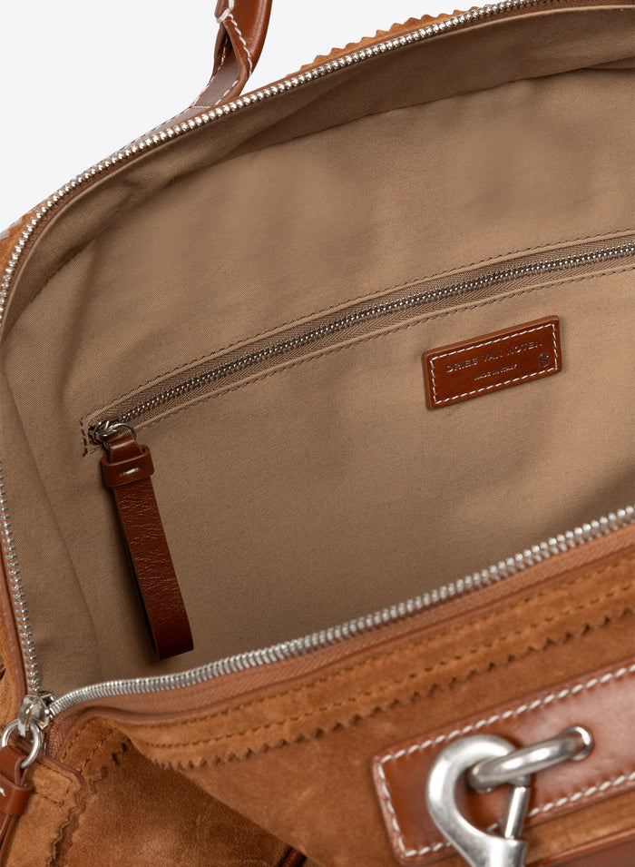 Close-up of a brown leather bag with visible stitching and hardware. - Dries Van Noten