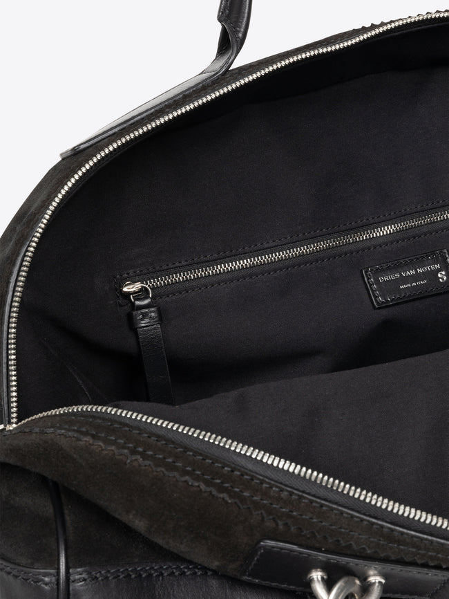 Close-up of a black leather bag with visible stitching and brand label. - Dries Van Noten