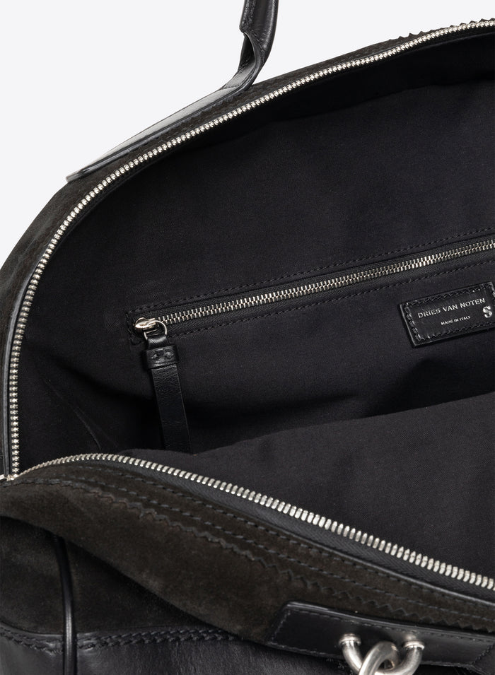 Close-up of a black leather bag with visible stitching and brand label. - Dries Van Noten