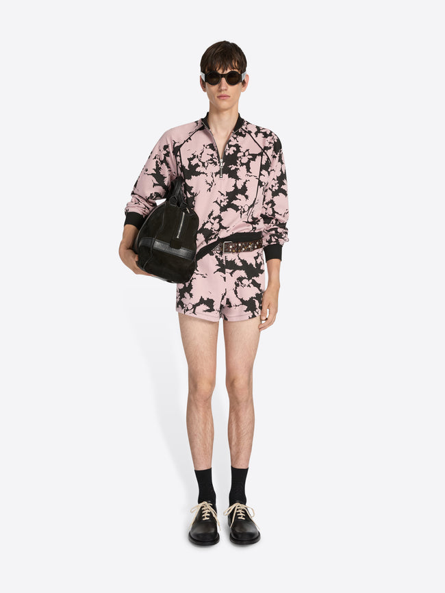 Person wearing a pink and black floral outfit with sunglasses and a black bag on a white background - Dries Van Noten