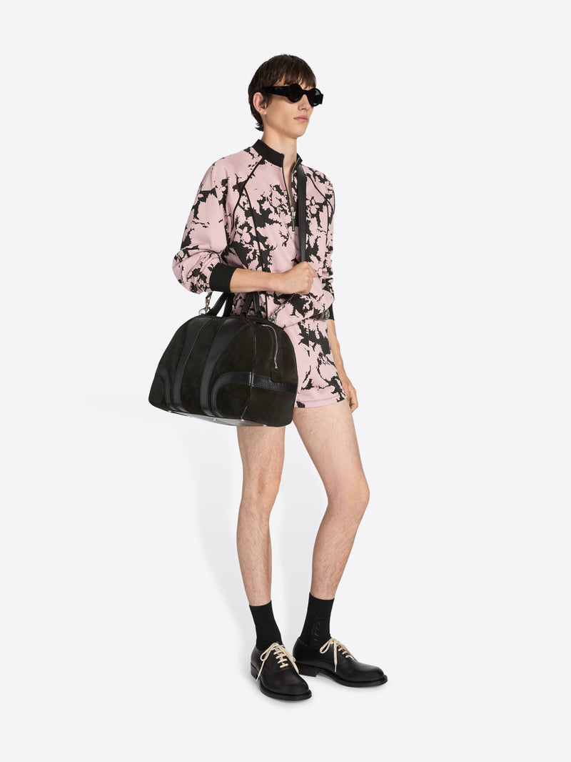 Person wearing a pink and black floral outfit with sunglasses and a black bag on a white background - Dries Van Noten