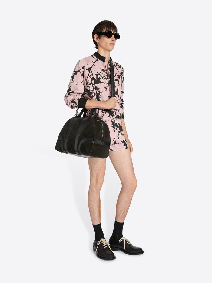 Person wearing a pink and black floral outfit with sunglasses and a black bag on a white background - Dries Van Noten