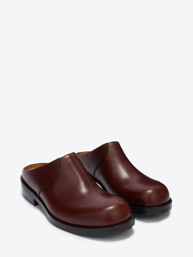 Pair of brown leather clogs on a white background