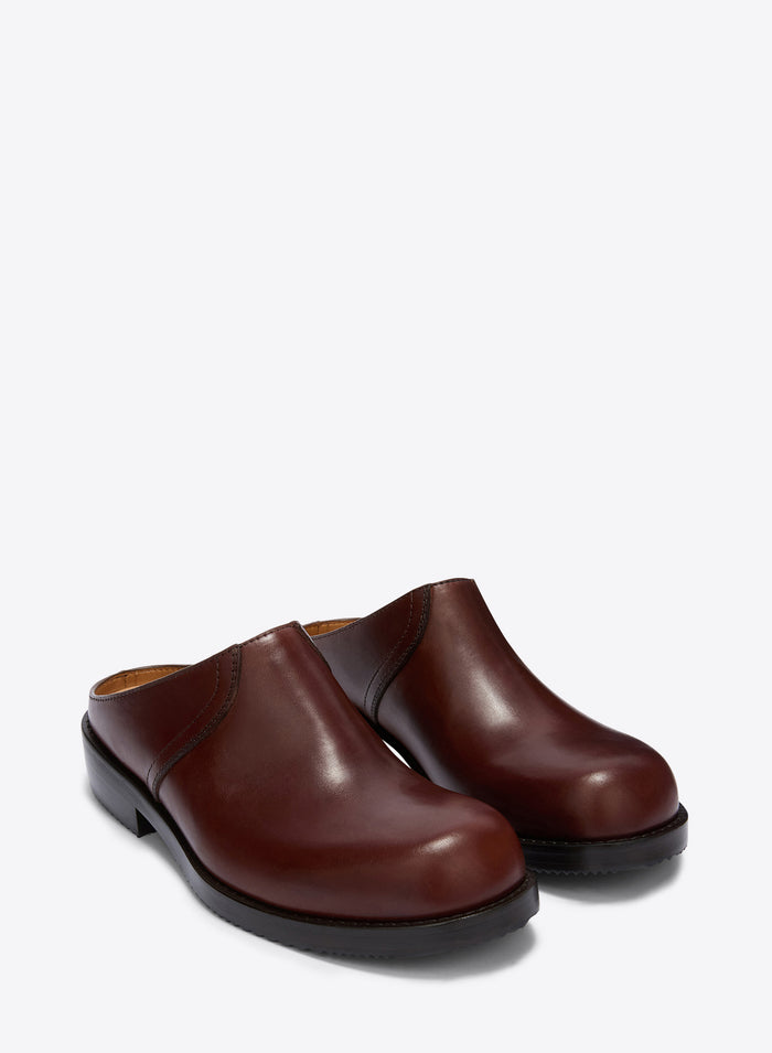 Pair of brown leather clogs on a white background
