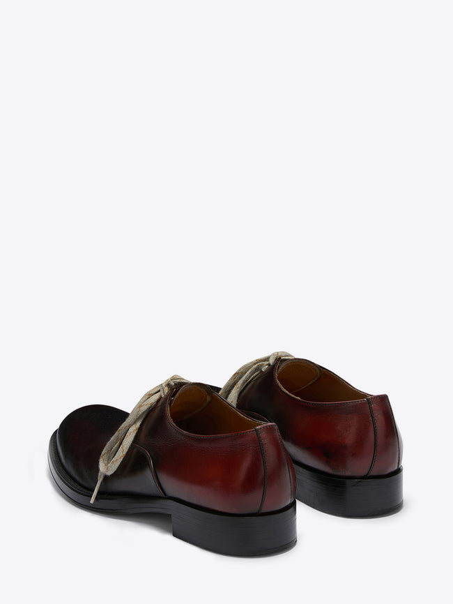 Pair of brown leather shoes with black soles on a white background
