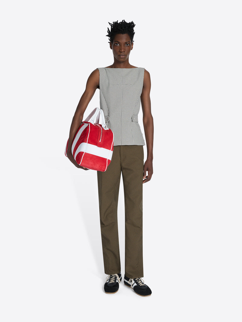 Person holding a red and white bag against a white background