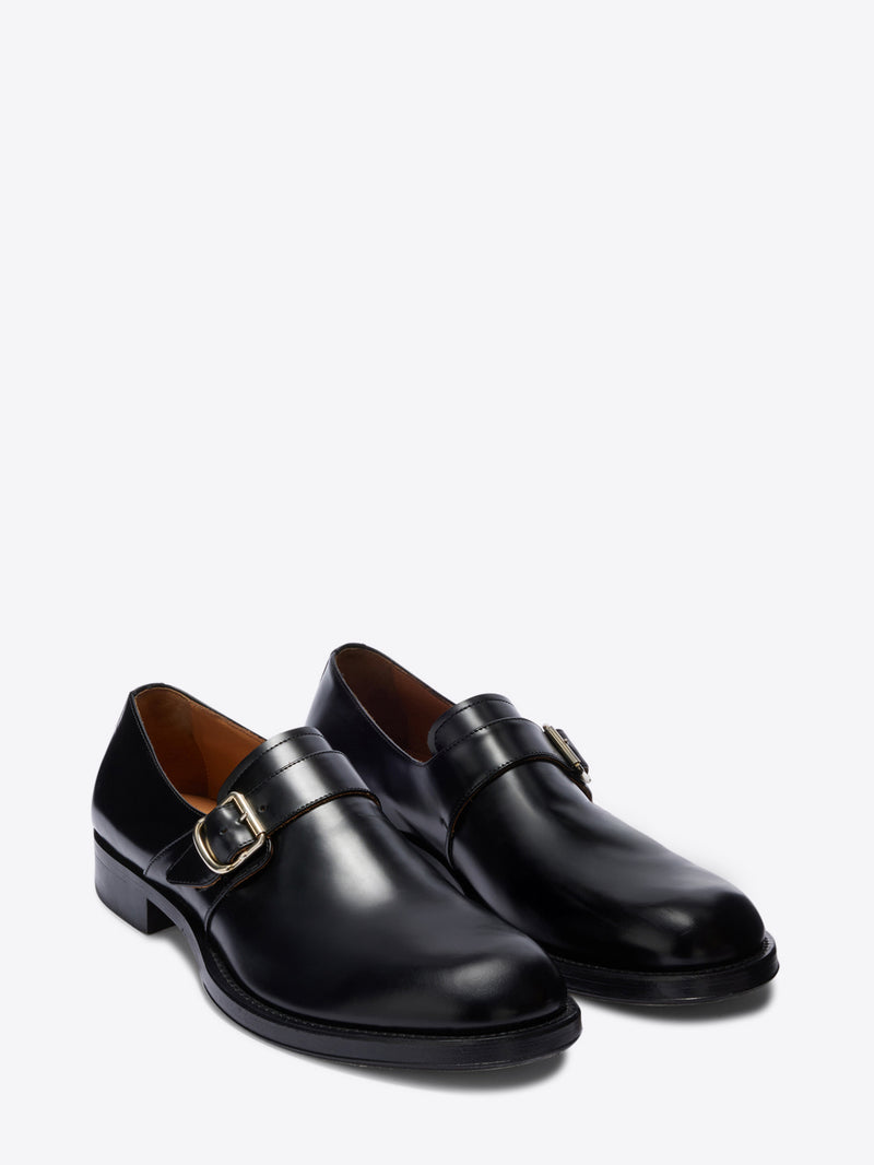 Pair of black leather shoes with buckles on a white background