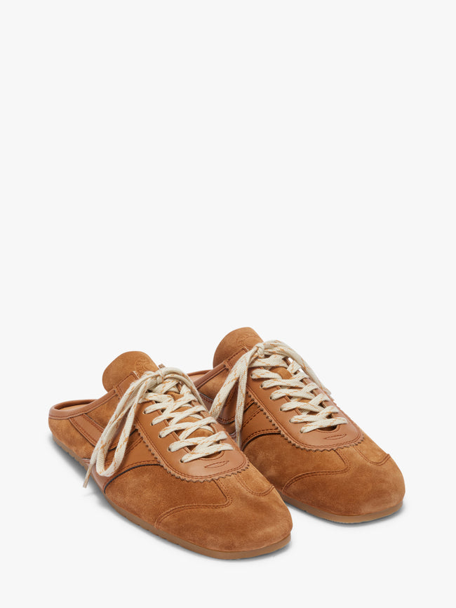 Pair of brown suede shoes with white laces on a white background