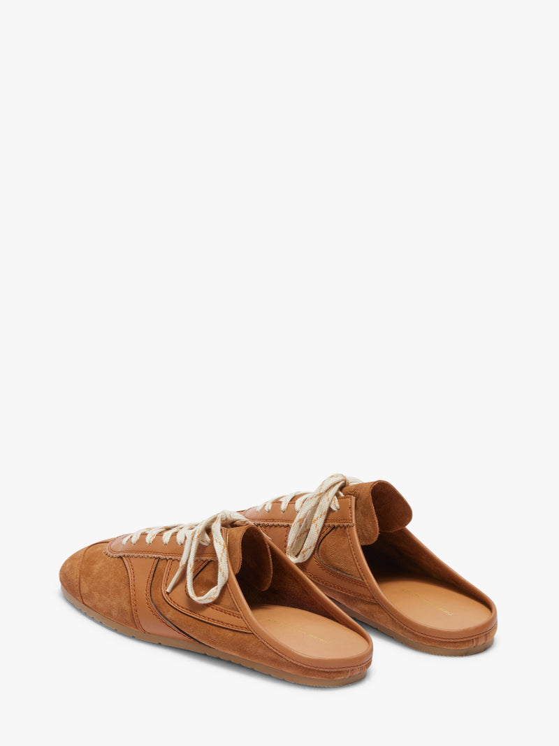 Pair of brown suede shoes with white laces on a white background
