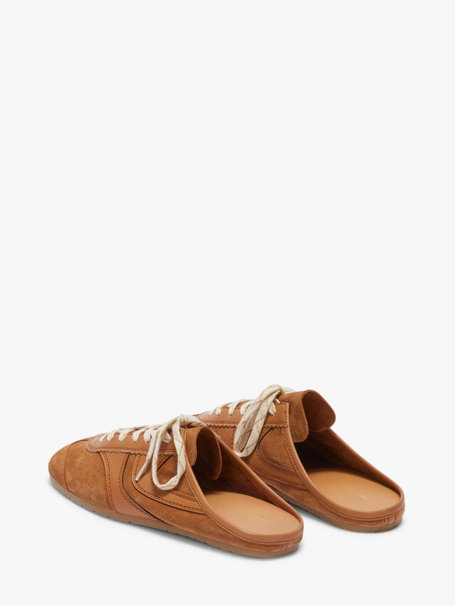 Pair of brown suede shoes with white laces on a white background