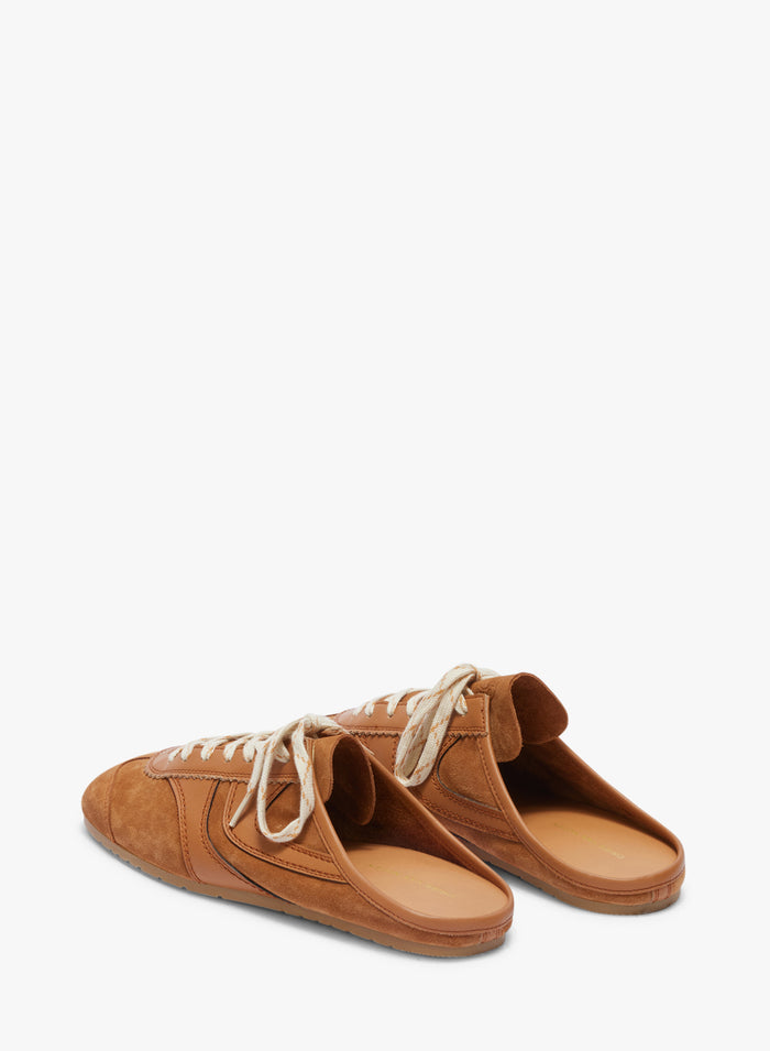 Pair of brown suede shoes with white laces on a white background