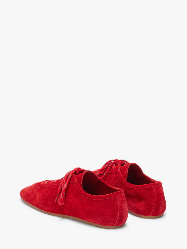 Pair of red suede shoes on a white background