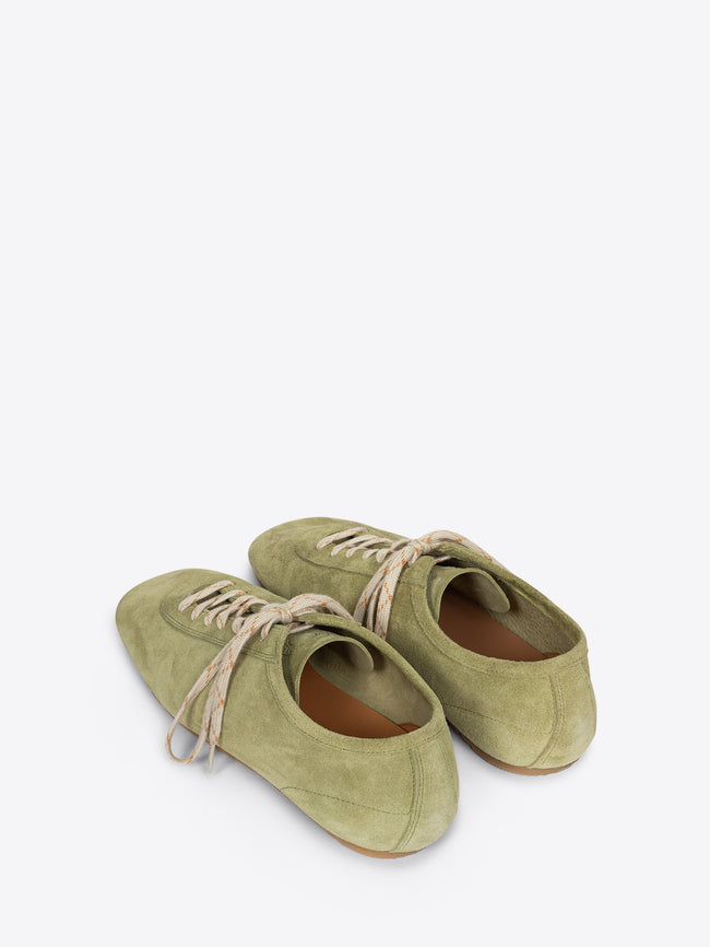 Pair of green shoes with brown soles on a white background