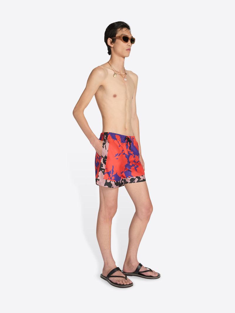 Man wearing colorful swim shorts on a white background