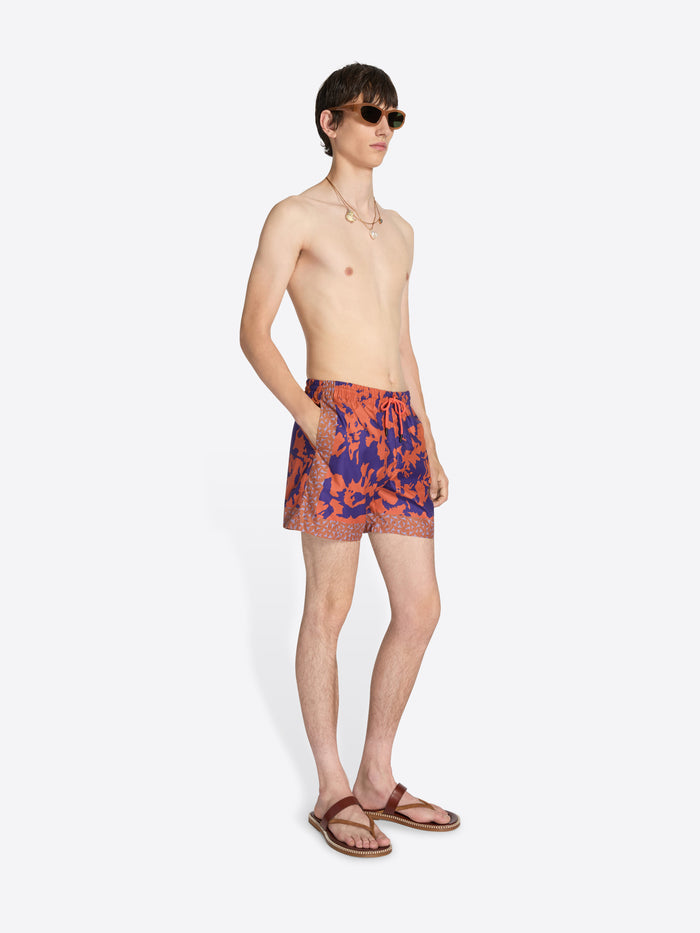 Man wearing colorful swim shorts on a white background