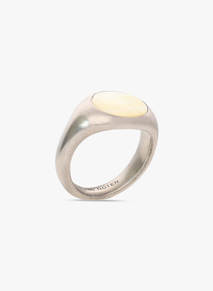 Silver ring with a yellow gemstone on a white background