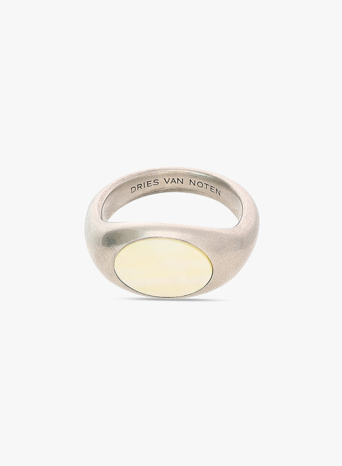 Silver ring with a yellow stone on a white background, featuring 'Dries Van Noten' branding.