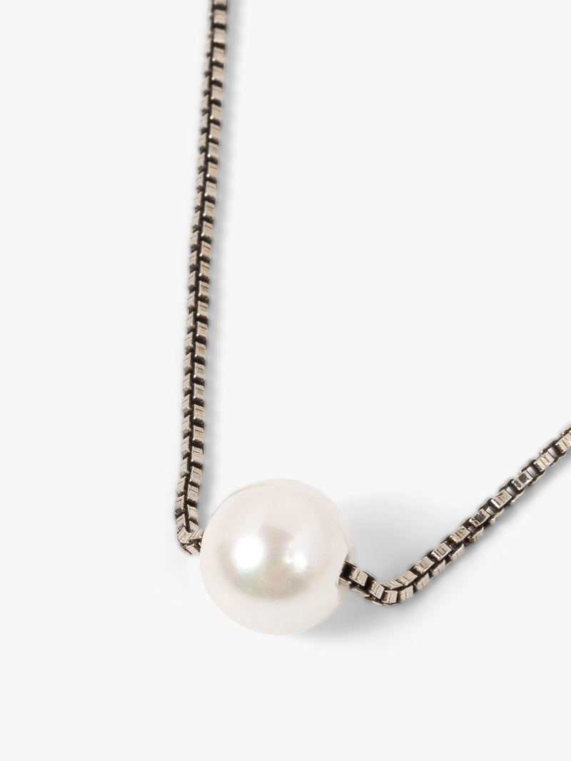 Pearl necklace with a chain on a white background
