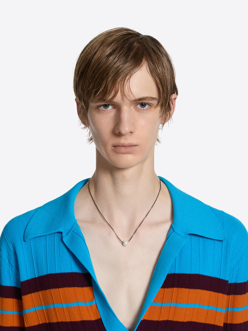 Man wearing a blue shirt with colorful stripes on a white background