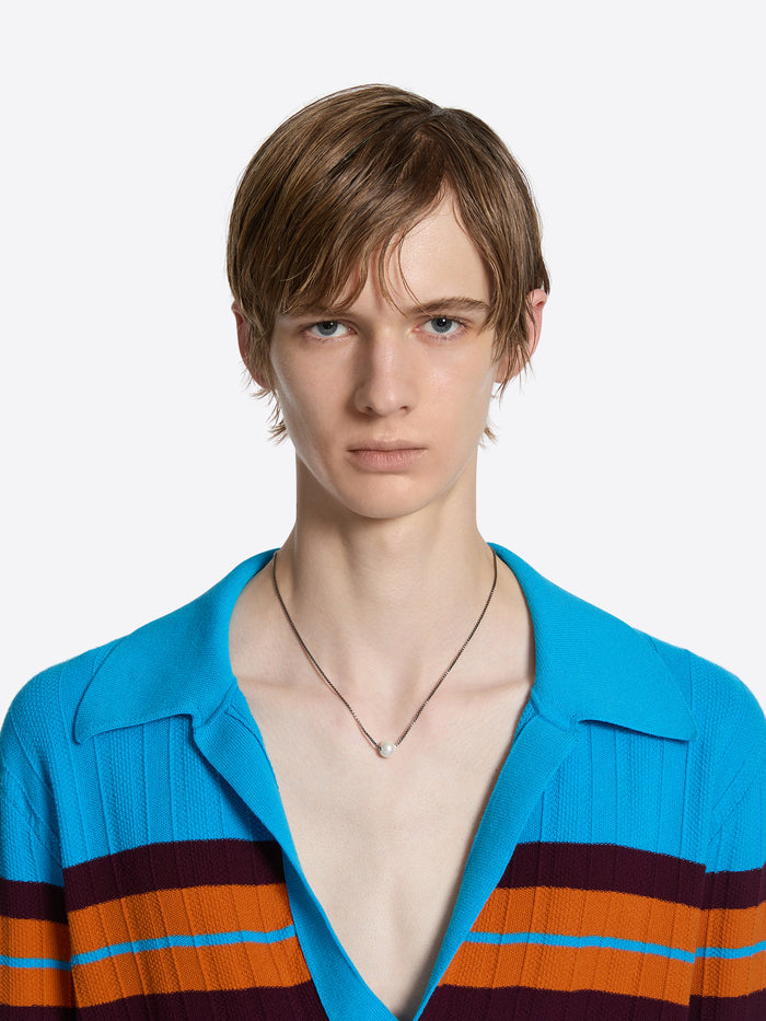 Man wearing a blue shirt with colorful stripes on a white background