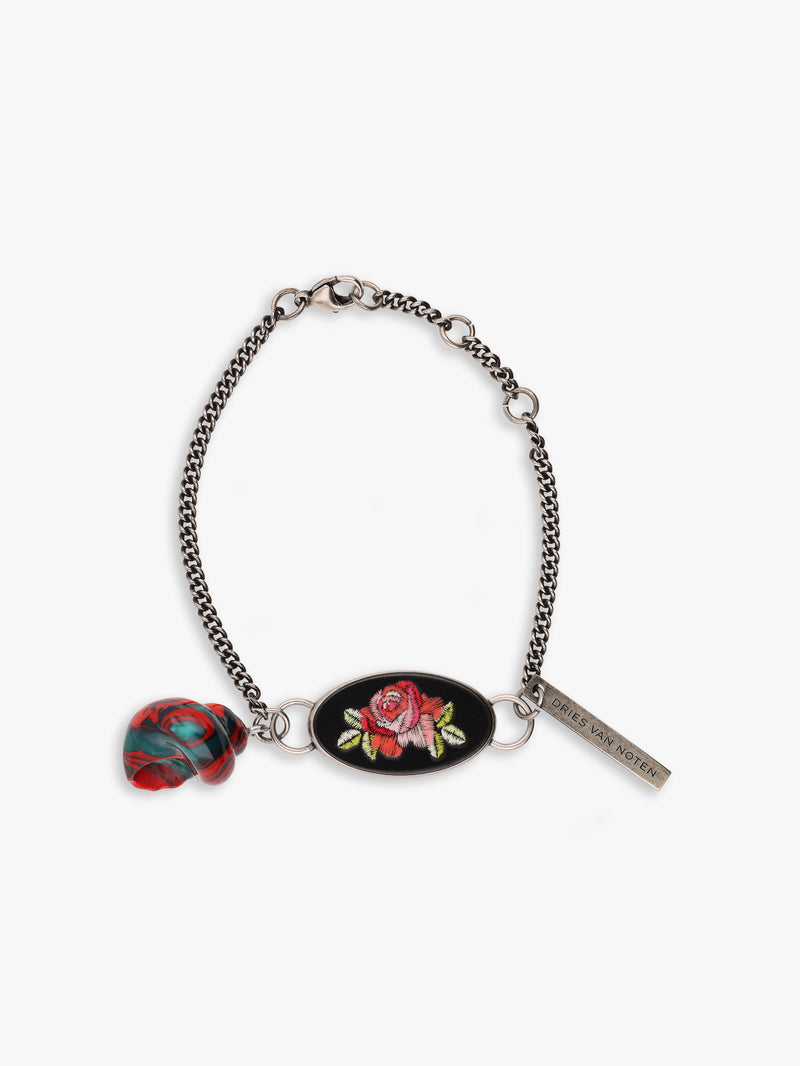 Bracelet with floral charm and tag on a white background