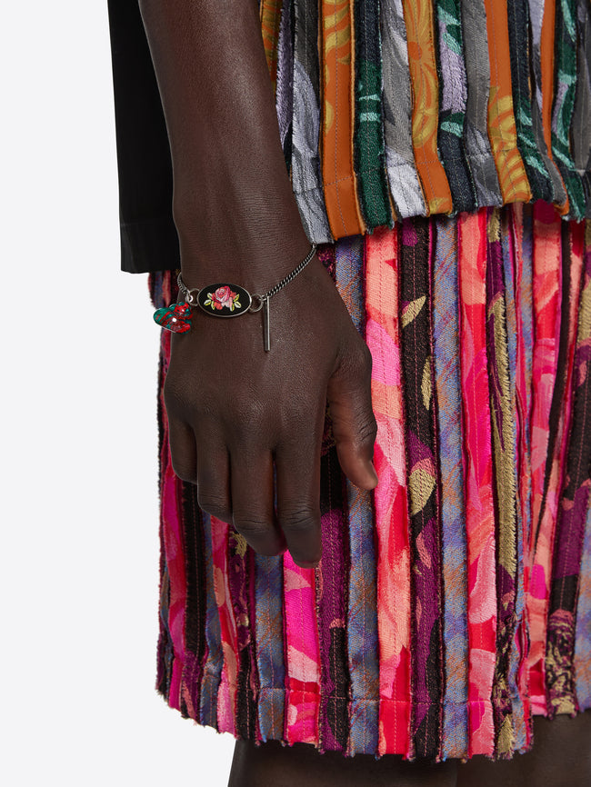 Colorful pleated shorts with a hand wearing a bracelet on a white background
